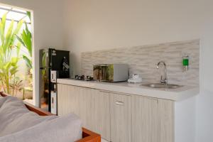 een keuken met een wastafel en een magnetron op een aanrecht bij 3BR Villa with Private pool in Selong Belanak