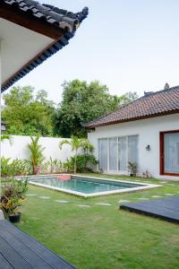 een achtertuin met een zwembad en een huis bij 3BR Villa with Private pool in Selong Belanak
