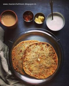a pizza in a pan on a table with other dishes at Wellawing Residency in Ludhiana