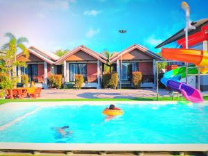 una casa con piscina con tobogán en มานิตา รีสอร์ท ปากพะยูน, en Phatthalung