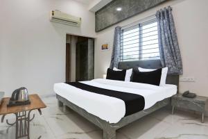 a bedroom with a large bed and a window at Hotel O Grand Embassy in Mānglia +44 photos