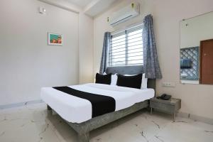 a bedroom with a large bed with a window at Hotel O Grand Embassy in Mānglia