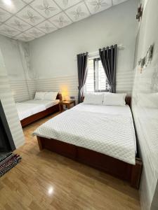 a bedroom with two beds and a window at 777 Hostel Vĩnh Hy in ThÃ´n Báº£o An