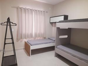 a bedroom with two bunk beds and a ladder at Apartamento praia do quilombo Centro - 02 in Penha