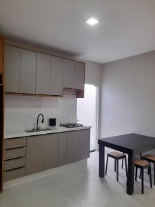 a kitchen with a table and a sink and a counter at Apartamento praia do quilombo Centro - 02 in Penha
