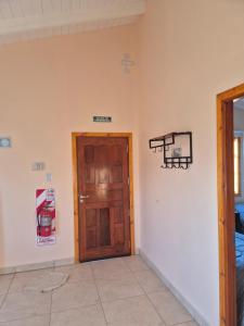 una camera con una porta in legno e un cartello sul muro di Costasueños a El Calafate