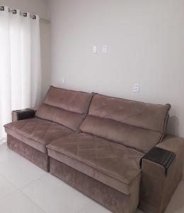 a brown leather couch in a living room at Apartamento praia do quilombo Centro - 02 in Penha +3 photos