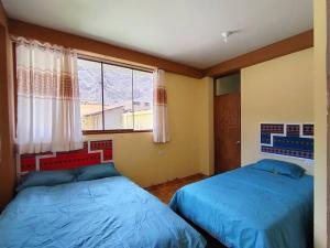 a bedroom with two beds and a window at Casa de la chakana Chakana House Sacred Valley in Calca