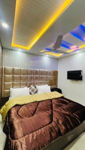 a bedroom with a large bed with a large headboard at Hotel 11 in Islamabad