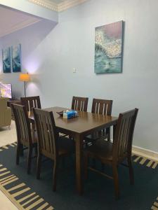 a dining room with a wooden table and chairs at D Ocean Homestay in Seri Manjung