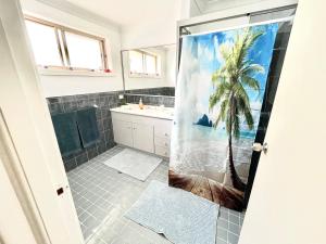 a bathroom with a shower with a palm tree at Tuncurry tranquility PID -STRA - 59456 in Tuncurry +36 photos