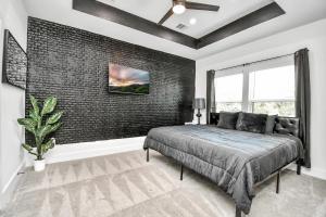 a bedroom with a bed and a brick wall at Cozy 3 Bedroom Townhouse in the Heart of Houston in Houston