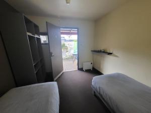 a room with two beds and a door to a patio at Swansea Backpackers in Swansea