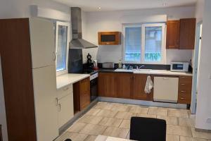 a kitchen with wooden cabinets and white appliances at L'étang pour soi in Socourt
