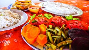 a table topped with plates of food with vegetables and rice at Itaúba Hotel Restaurante Eco-resort in Puerto Sucre