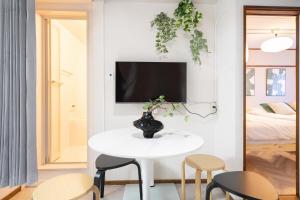 a small white table in a room with chairs and a tv at Midtown OIMACHI Hub in Tokyo