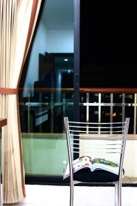 a chair sitting on a balcony with a window at Pattara Place in Chiang Mai