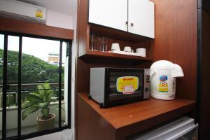 a microwave sitting on a shelf next to a window at Pattara Place in Chiang Mai