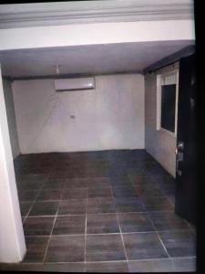 an empty garage with a tiled floor and white walls at Alojamiento en col independencia in Mexicali