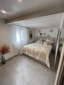 a bedroom with a bed and a large window at Confort en centre ville à moins de 15 min d Orly in Longjumeau