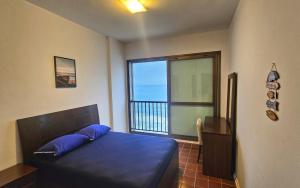 a bedroom with a bed and a large window at Linda Vista do Mar - Espaçoso - Praia Pitangueiras in Guarujá +35 photos