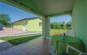 zadaszone patio ze stołem i żółtym budynkiem w obiekcie Studio Apartment In Sv,lovrec w mieście Jakići