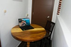a laptop computer sitting on top of a wooden table at Small and comfy loft near Atlixco's center in Atlixco +4 photos