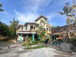 a large house with a swimming pool in front of it at The Vitamin Sea in Ambalangoda