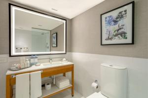a bathroom with a sink and a mirror and a toilet at Sheraton Buenos Aires Hotel & Convention Center in Buenos Aires