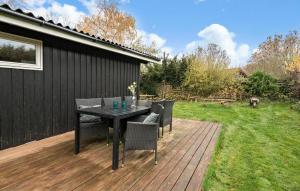 a patio with a table and chairs on a deck at 3 Bedroom Lovely Home In Kirke Hyllinge in Kirke-Hyllinge