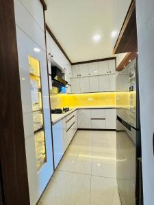 a kitchen with white cabinets and yellow accents at 6Floor in society Ecity ph2 Near TCS Tech Mahindra in Bengaluru