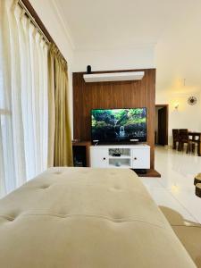 a bedroom with a bed and a flat screen tv at 6Floor in society Ecity ph2 Near TCS Tech Mahindra in Bengaluru