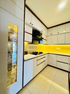 a kitchen with white cabinets and a yellow wall at 6Floor in society Ecity ph2 Near TCS Tech Mahindra in Bengaluru