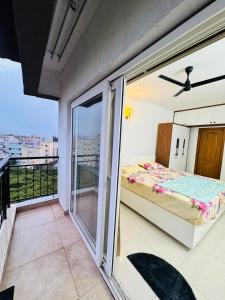 a bedroom with a bed and a balcony at 6Floor in society Ecity ph2 Near TCS Tech Mahindra in Bengaluru