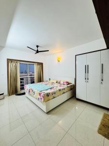 a white bedroom with a bed and a window at 6Floor in society Ecity ph2 Near TCS Tech Mahindra in Bengaluru