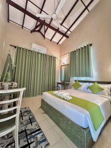 a bedroom with a large bed with green curtains at The Vitamin Sea in Ambalangoda +100 photos