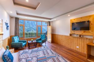 una camera con un letto e due sedie e una televisione di The 14 Gables, A Boutique Stay - Pet Friendly Hotel a Manāli