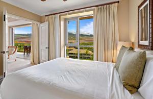 a bedroom with a white bed and a large window at Honua Kai Resort And Spa By Maui Resort Rentals in Lahaina