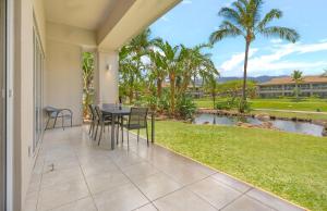 a patio with a table and chairs and a pond at Honua Kai Resort And Spa By Maui Resort Rentals in Lahaina