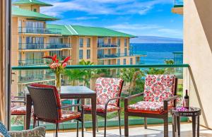a balcony with chairs and a table with a view of the ocean at Honua Kai Resort And Spa By Maui Resort Rentals in Lahaina