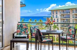 a balcony with a table and chairs and a view of the ocean at Honua Kai Resort And Spa By Maui Resort Rentals in Lahaina