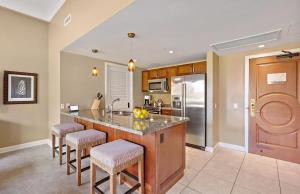 a kitchen with a large island with bar stools at Honua Kai Resort And Spa By Maui Resort Rentals in Lahaina
