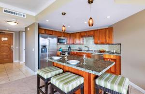 a kitchen with a island with bar stools at Honua Kai Resort And Spa By Maui Resort Rentals in Lahaina