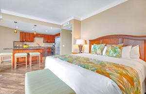a bedroom with a large bed and a kitchen at Honua Kai Resort And Spa By Maui Resort Rentals in Lahaina