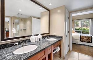 a bathroom with two sinks and a large mirror at Honua Kai Resort And Spa By Maui Resort Rentals in Lahaina