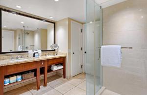 a bathroom with a shower and a sink and a mirror at Honua Kai Resort And Spa By Maui Resort Rentals in Lahaina