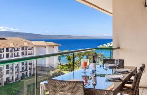 a balcony with a table with a view of the ocean at Honua Kai Resort And Spa By Maui Resort Rentals in Lahaina