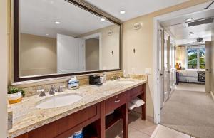 a bathroom with two sinks and a large mirror at Honua Kai Resort And Spa By Maui Resort Rentals in Lahaina