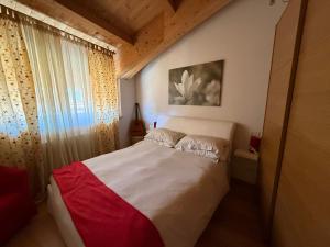 a bedroom with a white bed with a red blanket at Nel cuore di Castel di Sangro La Casa di Cristina in Castel di Sangro
