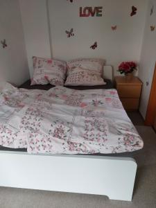 a bed with a pink and white comforter on it at Bungalow Teltow Seehof in Teltow